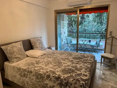 a bedroom with a bed and a patio with a table at Appartement T2 bord de mer in Cannes