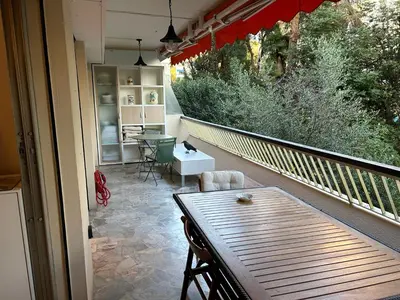 a patio with a table and chairs on a balcony at Appartement T2 bord de mer in Cannes