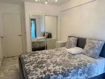 a bedroom with a bed and a mirror at Appartement T2 bord de mer in Cannes