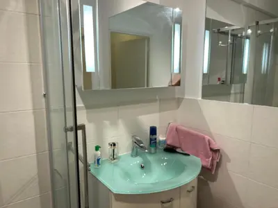 a bathroom with a sink and a shower with a mirror at Appartement T2 bord de mer in Cannes