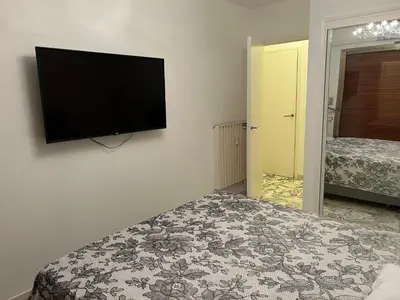 a bedroom with a flat screen tv on the wall at Appartement T2 bord de mer in Cannes
