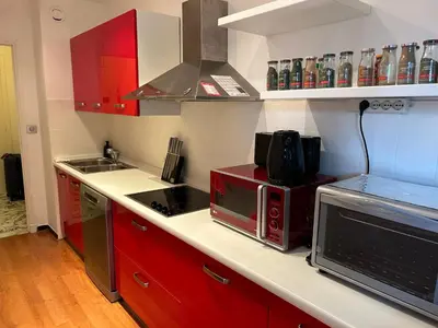 a kitchen with red cabinets and a microwave at Appartement T2 bord de mer in Cannes