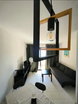 a living room with a couch and a table at Appartement 4 personnes sea view pool in Cannes