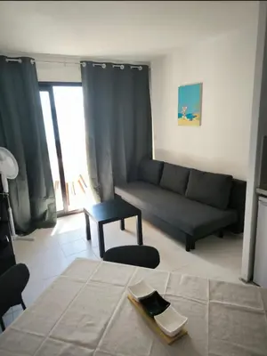 a living room with a couch and a table at Appartement 4 personnes sea view pool in Cannes