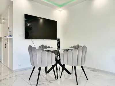 a dining room with a table with chairs and a flat screen tv at Gray D'Albion -2A8- 1 Chambre in Cannes