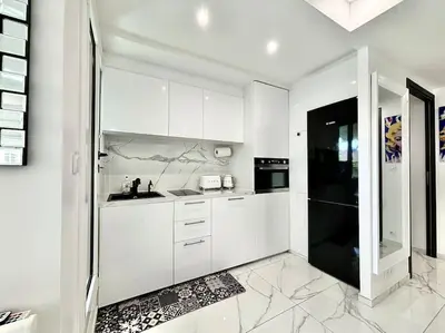 a kitchen with white cabinets and a black refrigerator at Gray D'Albion -2A8- 1 Chambre in Cannes