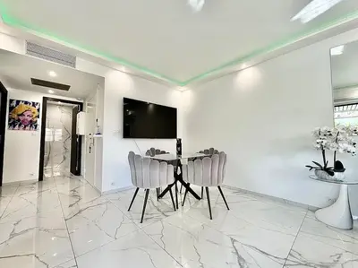 a dining room with a table and chairs and a television at Gray D'Albion -2A8- 1 Chambre in Cannes
