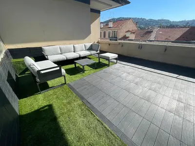 a couch and two tables on a roof at Cannes Appartement Terrasse Parking privé in Cannes