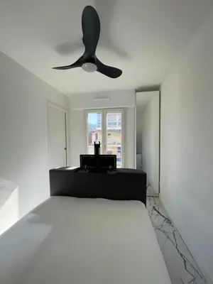 a bedroom with a bed with a ceiling fan at Cannes Appartement Terrasse Parking privé in Cannes