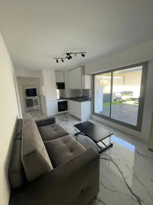a living room with a couch and a large window at Cannes Appartement Terrasse Parking privé in Cannes