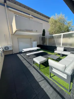 a patio with white benches and tables on a building at Cannes Appartement Terrasse Parking privé in Cannes