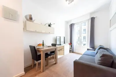a living room with a table and a couch at Cannes 1-Br Apartment in the Carré d’Or in Cannes