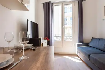 a living room with a couch and a table with wine glasses at Cannes 1-Br Apartment in the Carré d’Or in Cannes