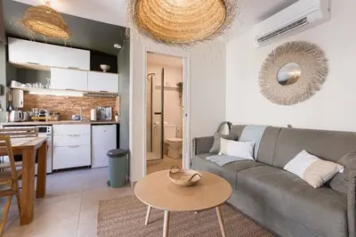 a living room with a couch and a table and a kitchen at Kaméa - Palais & plage, clim, vieux Suquet, port in Cannes