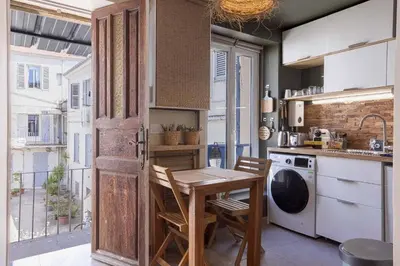 a small kitchen with a wooden table and a sink at Kaméa - Palais & plage, clim, vieux Suquet, port in Cannes