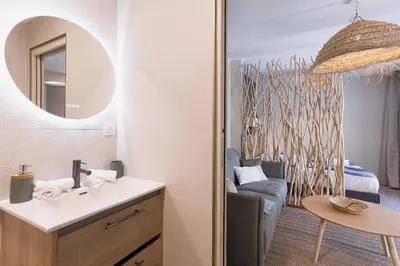 a bathroom with a sink and a mirror and a couch at Kaméa - Palais & plage, clim, vieux Suquet, port in Cannes