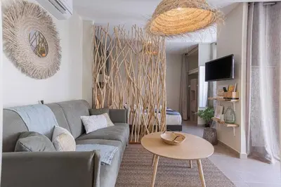 a living room with a couch and a table at Kaméa - Palais & plage, clim, vieux Suquet, port in Cannes