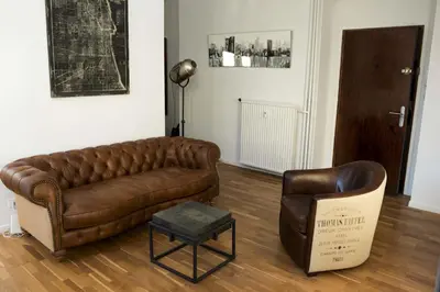 a living room with a brown leather couch and a chair at Appartement Cannes rue Marceau in Cannes