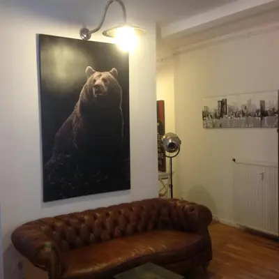 a couch in a living room with a painting of a bear at Appartement Cannes rue Marceau in Cannes