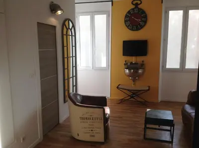 a living room with a couch and a clock on the wall at Appartement Cannes rue Marceau in Cannes