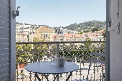 a table on a balcony with a view of a city at Studio Jules - Bd de Lorraine in Cannes