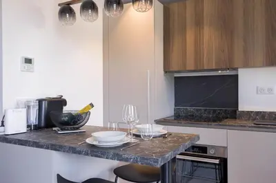 a kitchen with a counter with plates and wine glasses at Studio Jules - Bd de Lorraine in Cannes
