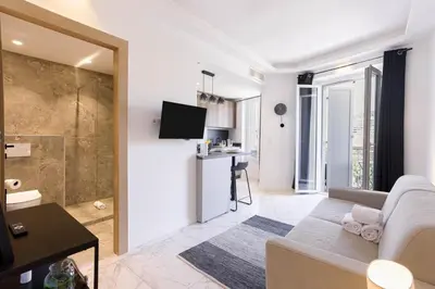 a living room with a couch and a tv at Studio Jules - Bd de Lorraine in Cannes