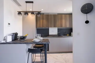 a kitchen with a counter and a clock on the wall at Studio Jules - Bd de Lorraine in Cannes