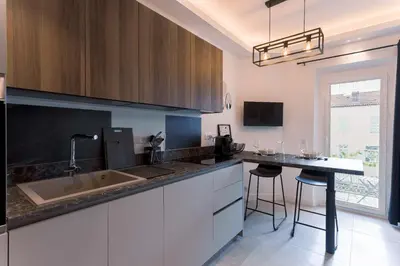 a kitchen with a sink and a counter with stools at Studio Charlie - Bd de Lorraine in Cannes