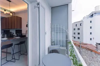 a balcony with a white stool and a kitchen at Studio Charlie - Bd de Lorraine in Cannes