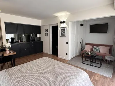 a bedroom with a bed and a couch and a kitchen at Modern studio in the hearth of Cannes just a few steps from the Croisette beach front and shops - 2242 in Cannes