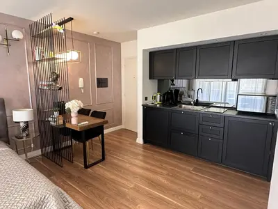 a kitchen with black cabinets and a table in a room at Modern studio in the hearth of Cannes just a few steps from the Croisette beach front and shops - 2242 in Cannes