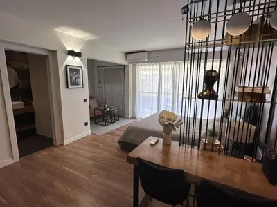 a living room with a table and a bed at Modern studio in the hearth of Cannes just a few steps from the Croisette beach front and shops - 2242 in Cannes