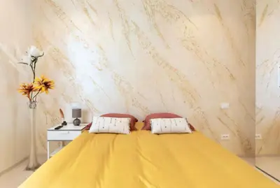 a yellow bed with two pillows in a bedroom at 3 ROOMS - DOWNTOWN CANNES - 2 MIN FROM PALAIS Festivals in Cannes
