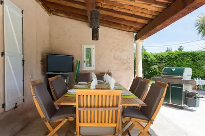 a dining room with a table and a pool at Spacious Villa Vallauris Cannes with AC throughout and large private pool in Vallauris