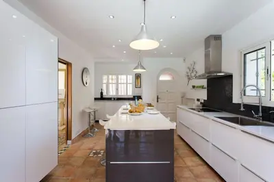 a kitchen with a white counter top and a table at Spacious Villa Vallauris Cannes with AC throughout and large private pool in Vallauris