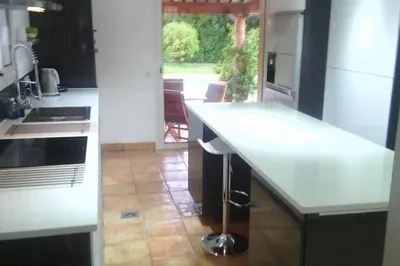 a large kitchen with white cabinets and a large island at Spacious Villa Vallauris Cannes with AC throughout and large private pool in Vallauris