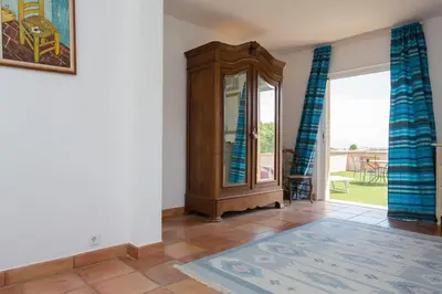 a bedroom with a white bed and blue curtains at Spacious Villa Vallauris Cannes with AC throughout and large private pool in Vallauris
