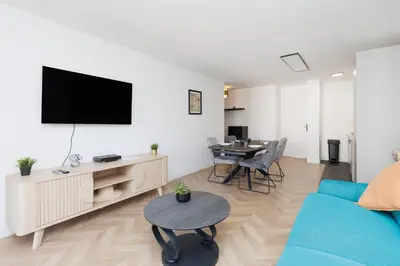 a living room with a blue couch and a table at Appartement 3 pièces, parking, 6mn de la Croisette in Cannes