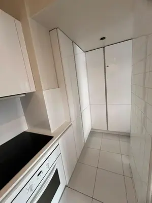 a white kitchen with white cabinets and a stove at Appartement terrasse Croisette in Cannes