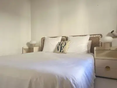 a white bed with white sheets and pillows at Appartement terrasse Croisette in Cannes