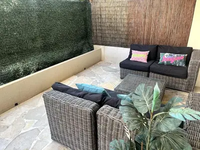 a living room with wicker chairs and a couch at Appartement terrasse Croisette in Cannes