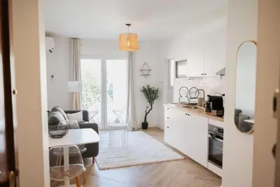 a kitchen and living room with a couch and a table at LA BELLE PLAGE près de la plage du Midi, Palais des Festivals et centre-ville in Cannes