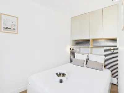 a white bedroom with a large white bed at LA BELLE PLAGE près de la plage du Midi, Palais des Festivals et centre-ville in Cannes