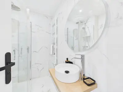 a white bathroom with a sink and a mirror at LA BELLE PLAGE près de la plage du Midi, Palais des Festivals et centre-ville in Cannes