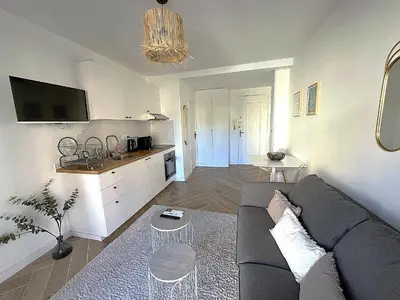 a living room with a couch and a kitchen at LA BELLE PLAGE près de la plage du Midi, Palais des Festivals et centre-ville in Cannes