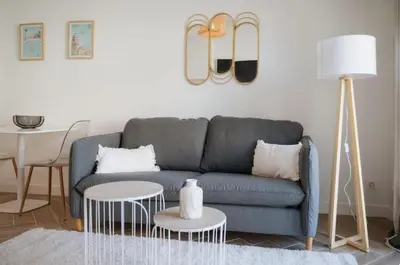 a living room with a blue couch and a table at LA BELLE PLAGE près de la plage du Midi, Palais des Festivals et centre-ville in Cannes