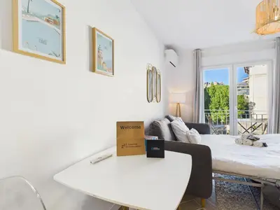 a white room with a white table and a bed at LA BELLE PLAGE près de la plage du Midi, Palais des Festivals et centre-ville in Cannes