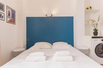 a bed with two towels on it with a blue wall at 