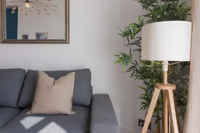 a lamp sitting next to a couch with a pillow at 